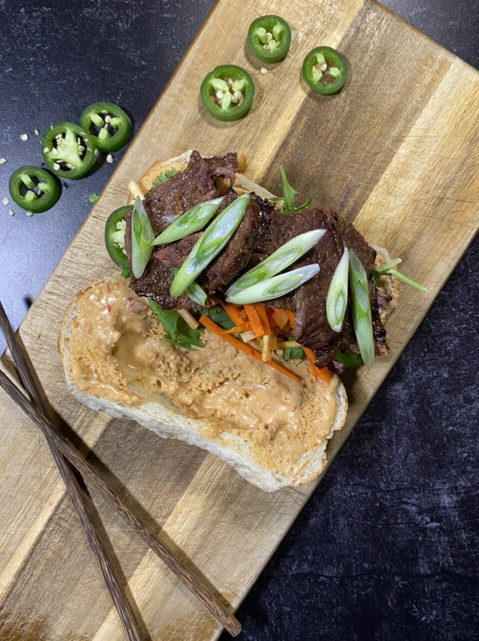 Asian short rib Banh mi sandwich on top of a cutting board 