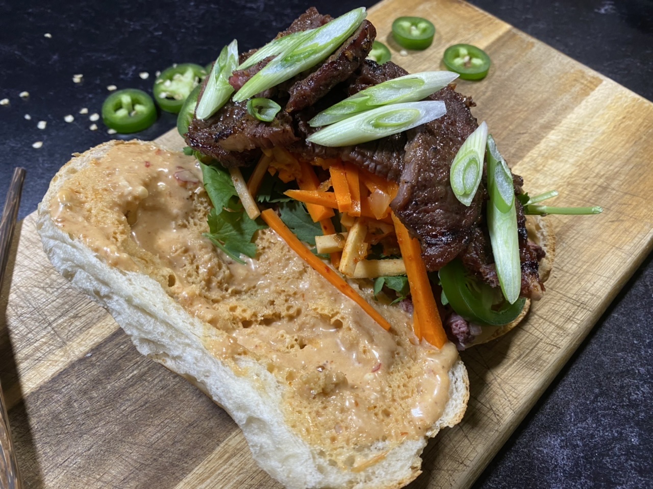 Asian short rib Banh mi sandwich on top of a cutting board 