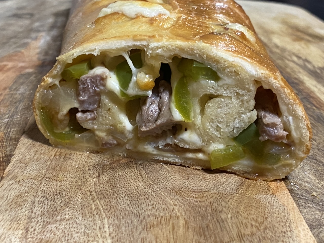 Philly cheesesteak Stromboli on top of a cutting board