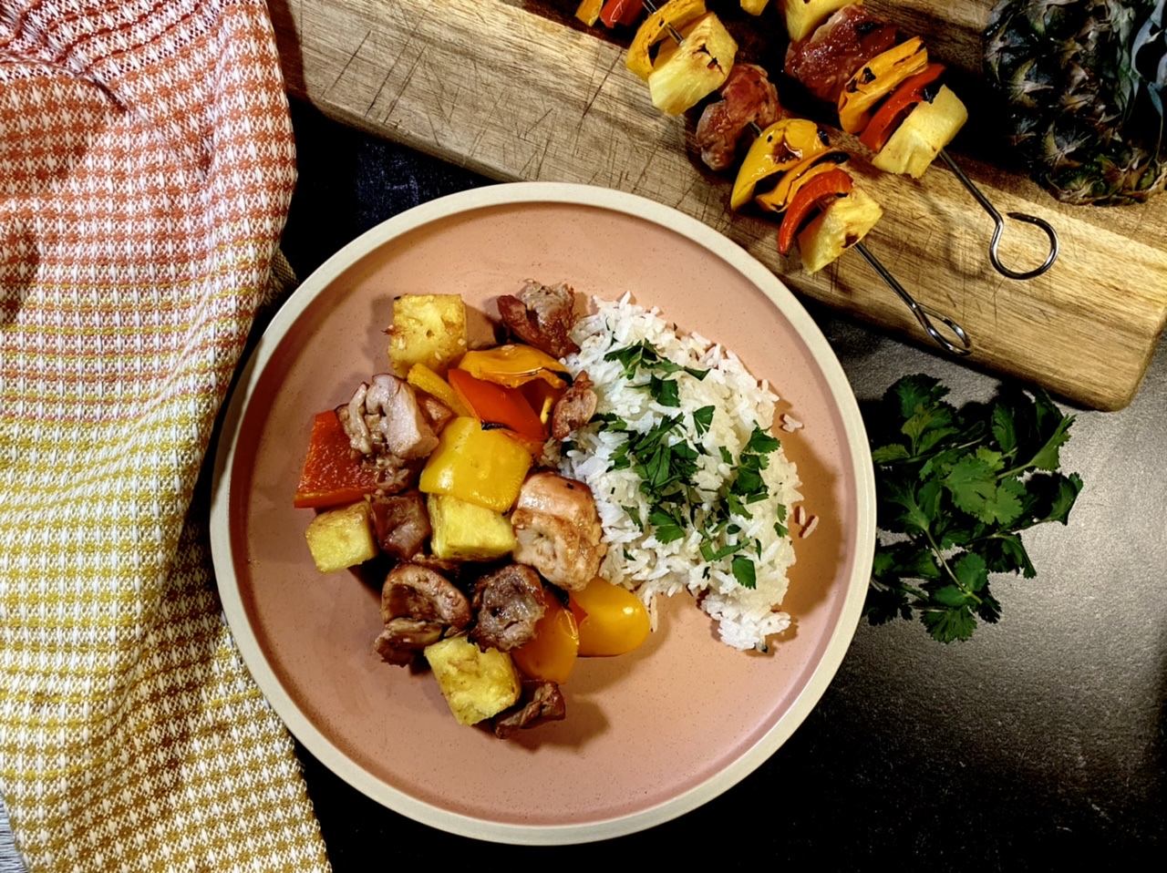 Hawaiian chicken, pepper, and pineapple kebabs with coconut rice on a pink plate
