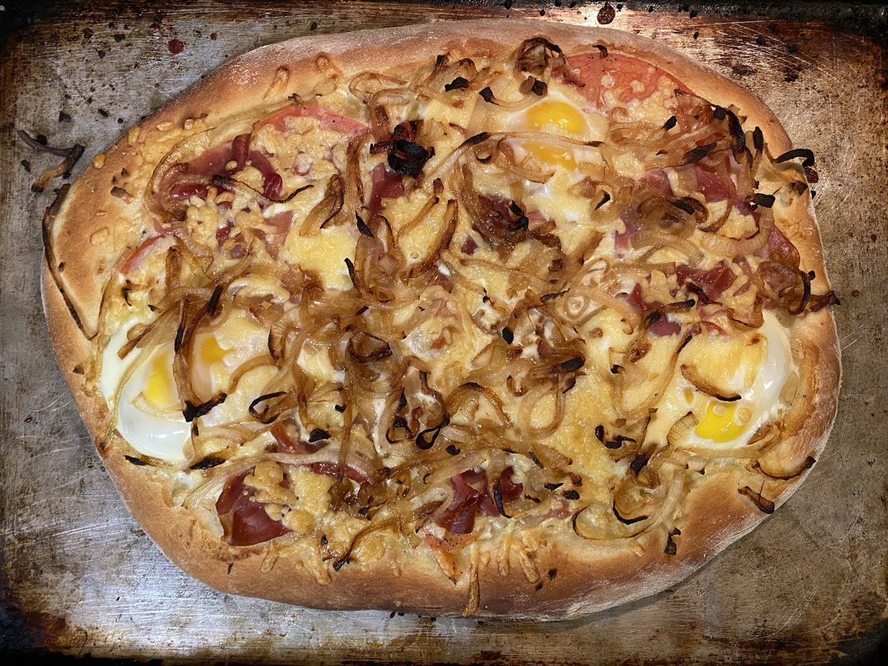 Everything bagel breakfast pizza on a baking sheet