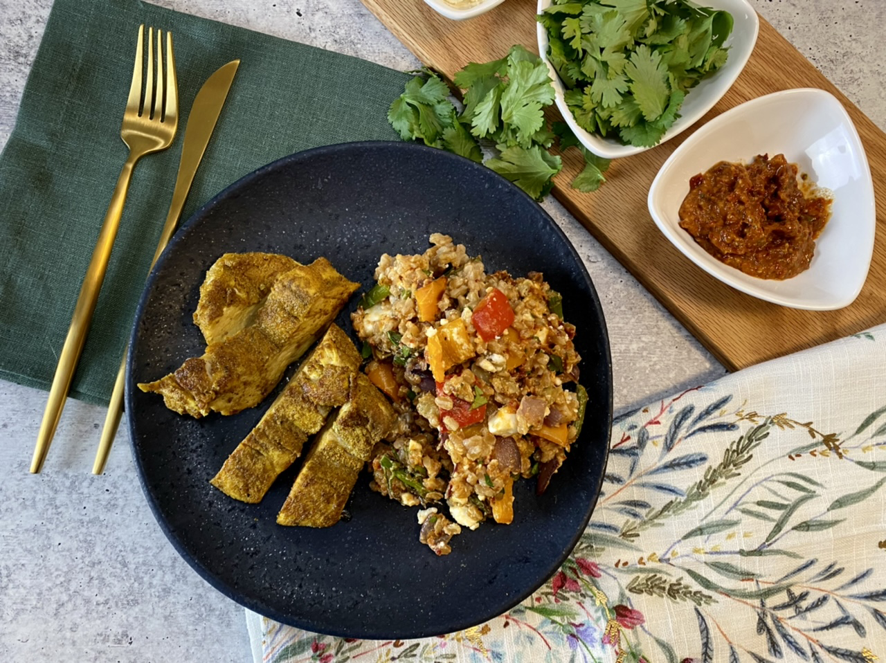 Mediterranean chicken with roasted vegetable farro salad on a blue plate