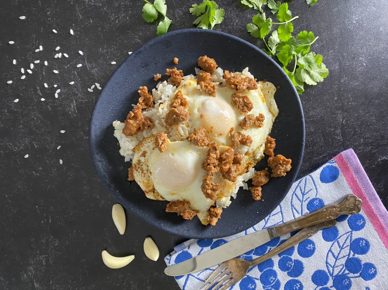 Tocilog Filipino breakfast with eggs, rice, and chorizo on a blue plate