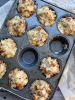 Grated hash brown potatoes in a muffin tray next to a baking rack