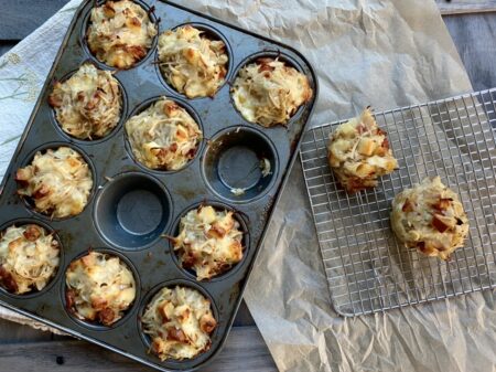 Grated hash brown potatoes in a muffin tray next to a baking rack
