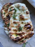 Grilled garlic naan on parchment paper