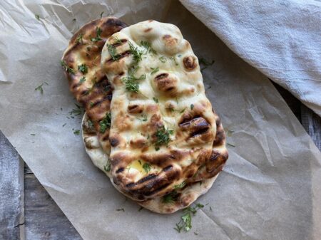 Grilled garlic naan on parchment paper